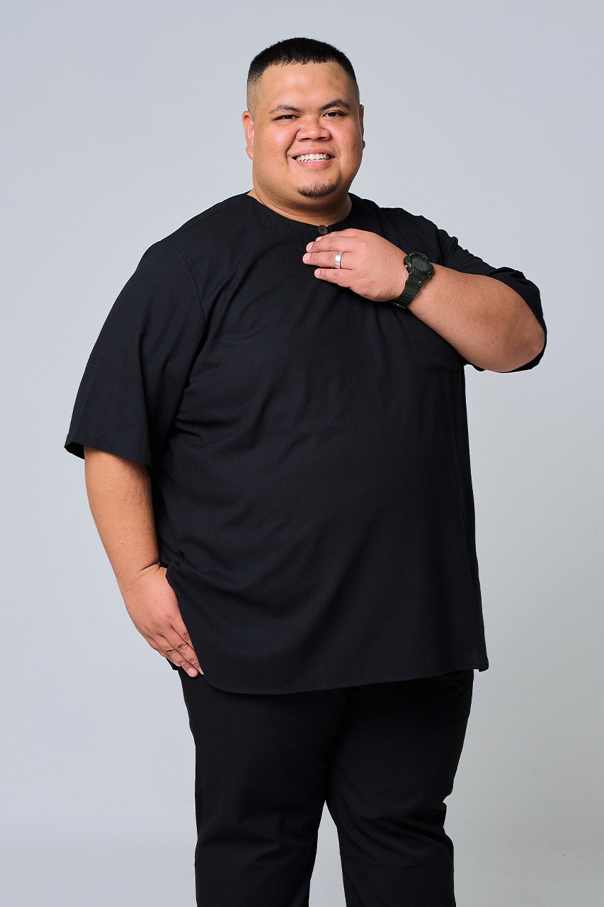 Man wearing a black shirt and pants on a plain background. #color_black