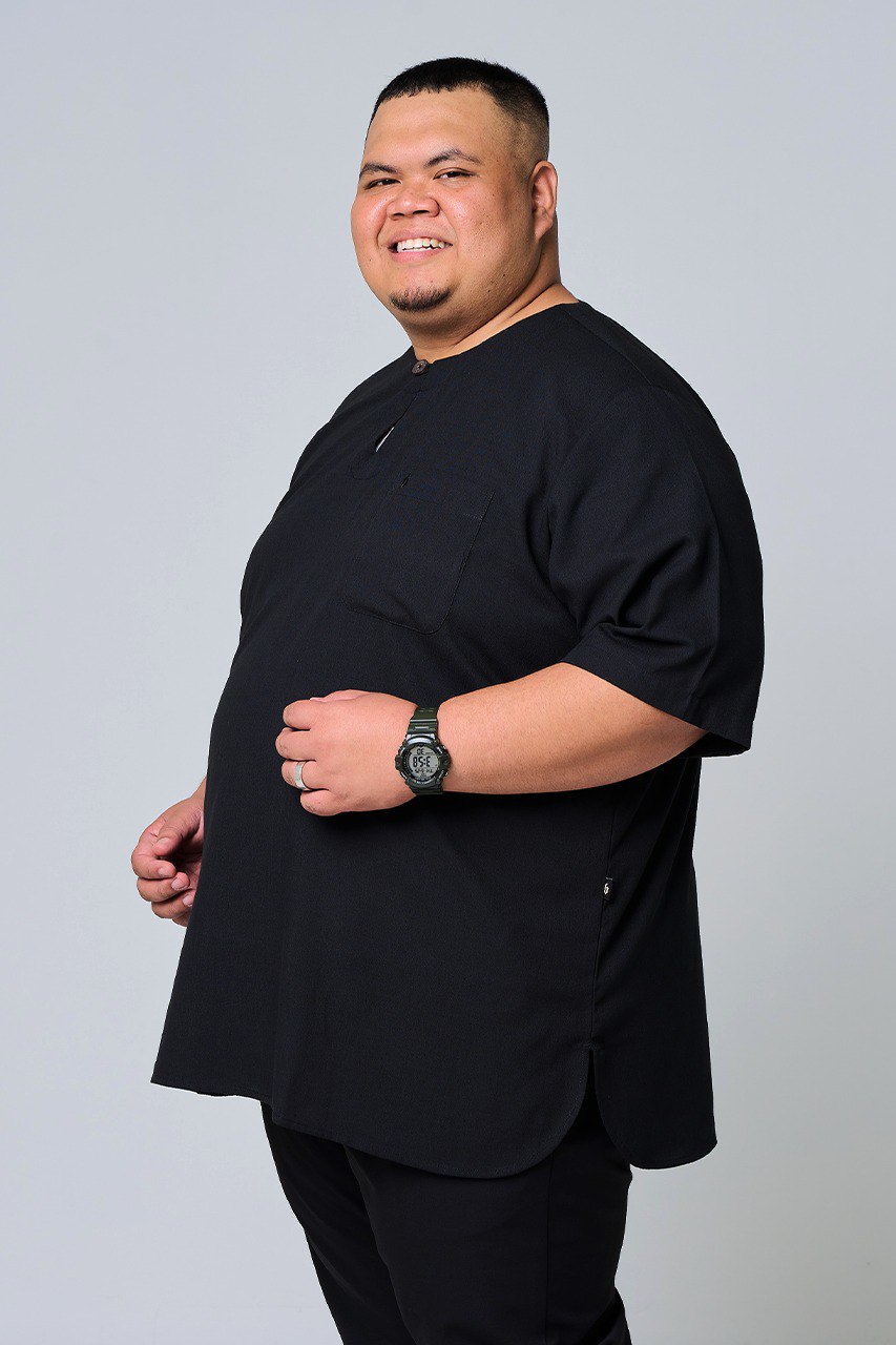 Man wearing a black outfit against a plain background #color_black