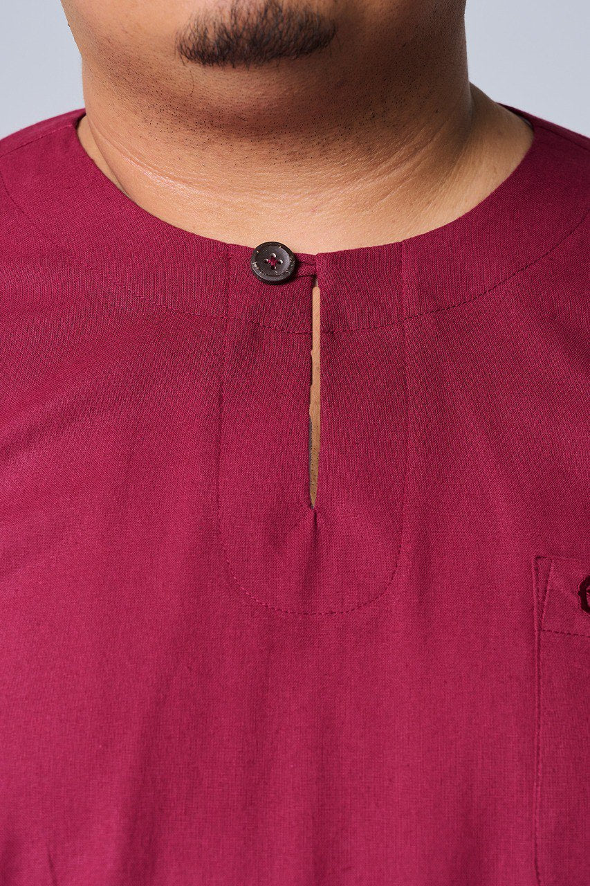 Close-up of a maroon shirt with a button and pocket detail. #color_maroon