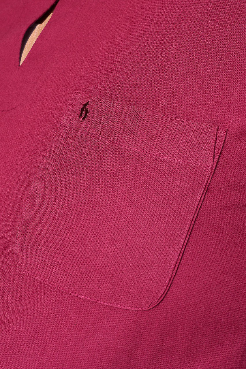 Close-up of a maroon shirt with a pocket and brand logo. #color_maroon