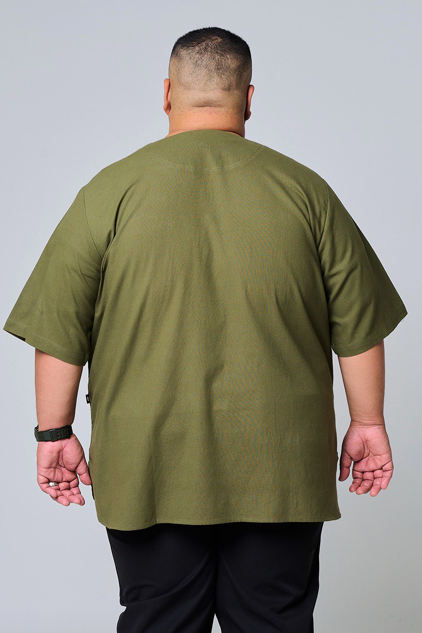 Person wearing an olive green shirt on a plain background #color_olive green