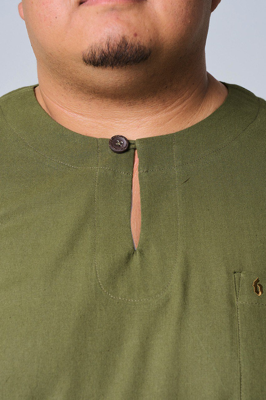 Close-up of a person wearing an olive green shirt with a button detail. #color_olive green