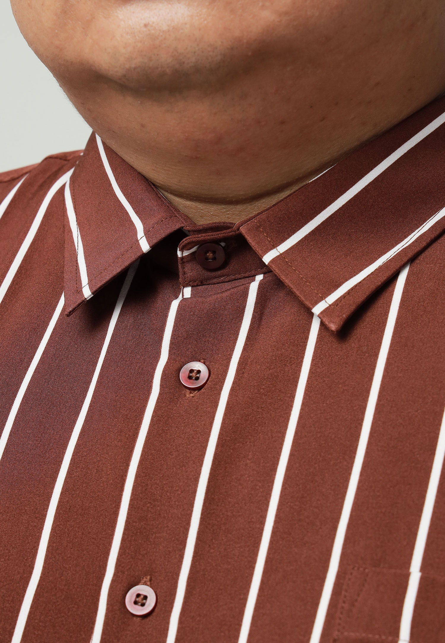 A close up of pointed collar for brown shirt with white stripes #color_brown