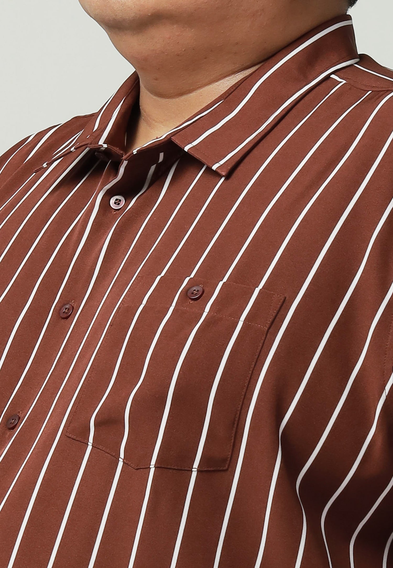 A close up of pointed collar and left chest pocket with button for brown shirt with white stripes #color_brown