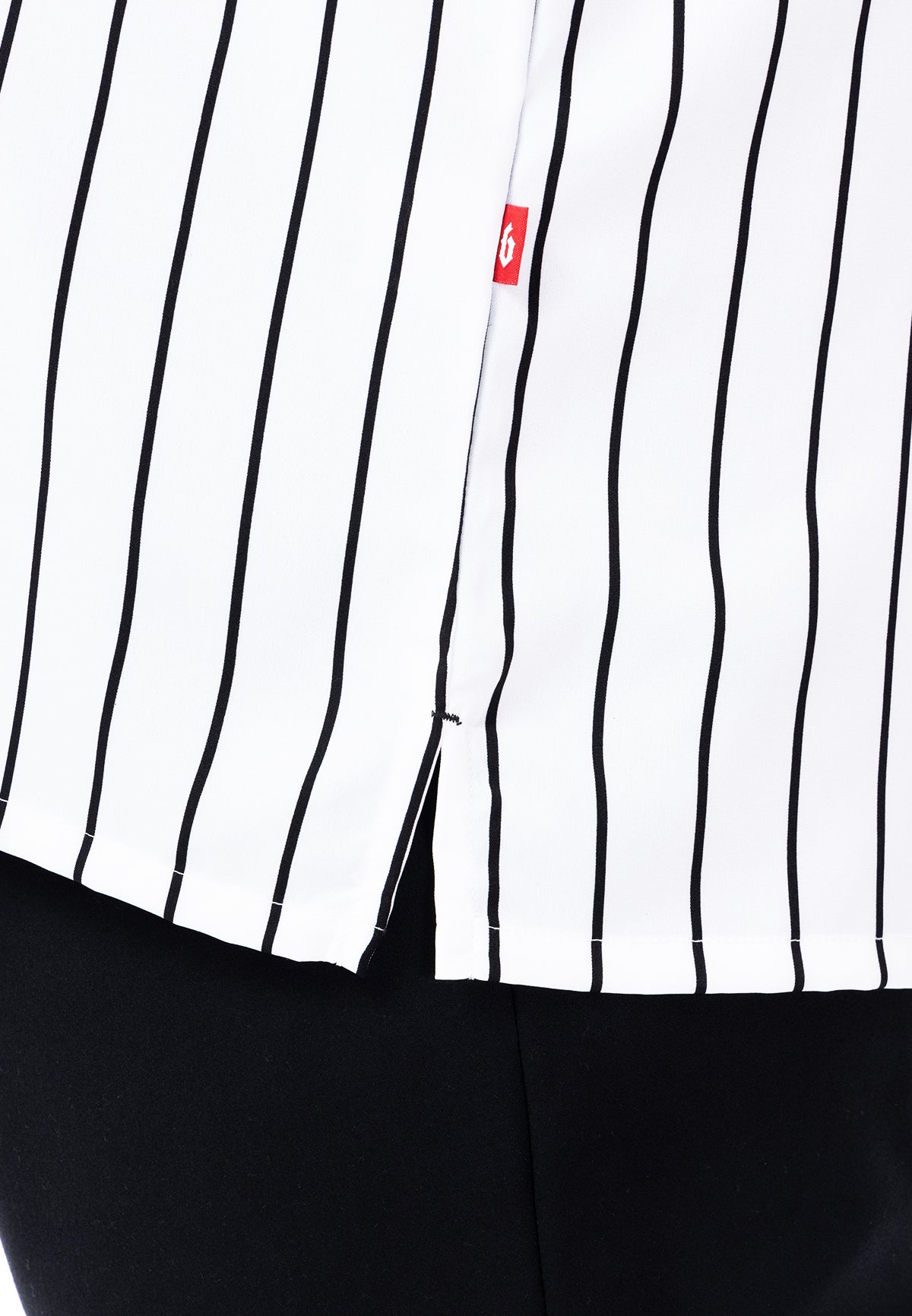 A close-up of the slit with a 'B' flag tag logo on a white shirt with black stripes. #color_white